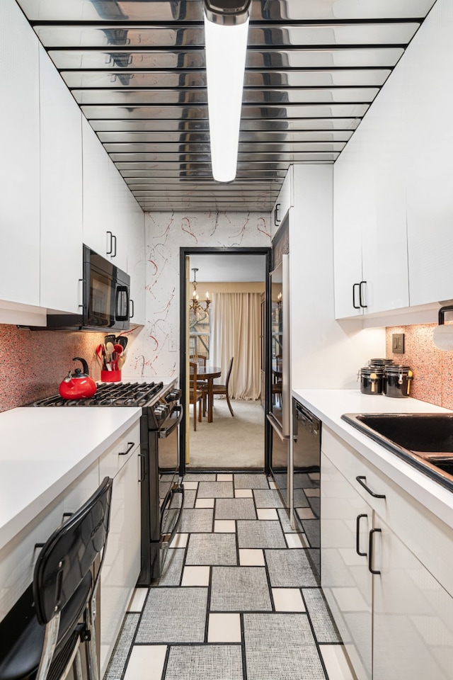 kitchen with a notable chandelier, white cabinetry, light countertops, decorative backsplash, and black appliances