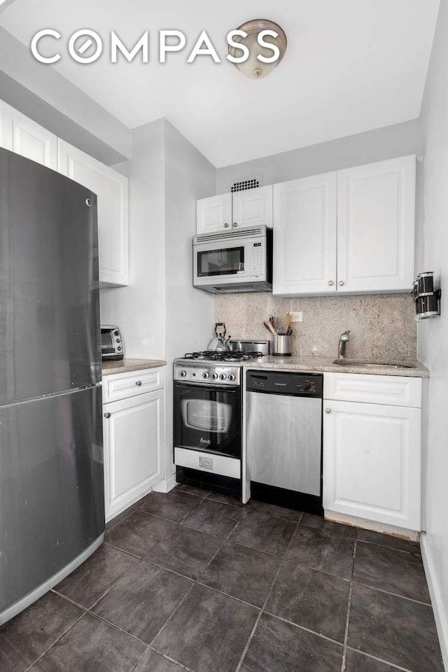 kitchen featuring stainless steel appliances, tasteful backsplash, and white cabinets