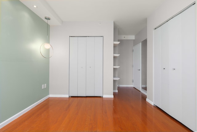unfurnished bedroom with baseboards and wood finished floors