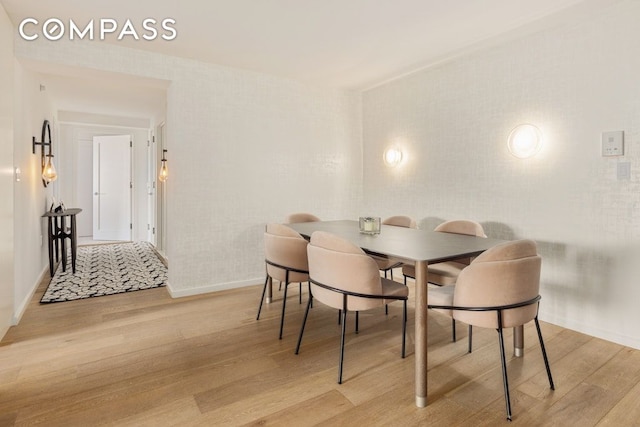 dining area with light wood-style flooring and baseboards