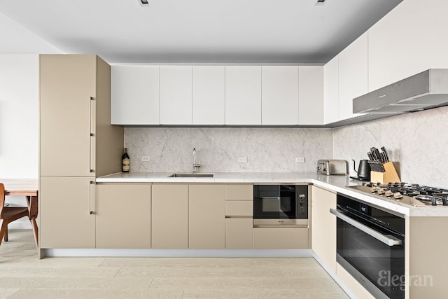 kitchen with light countertops, appliances with stainless steel finishes, light wood-style floors, a sink, and modern cabinets