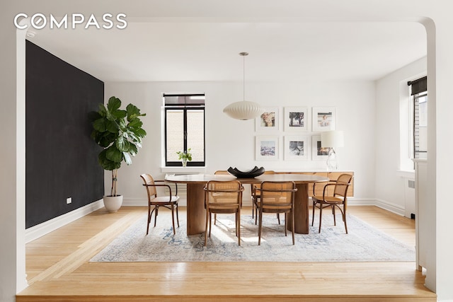 dining space with baseboards and wood finished floors