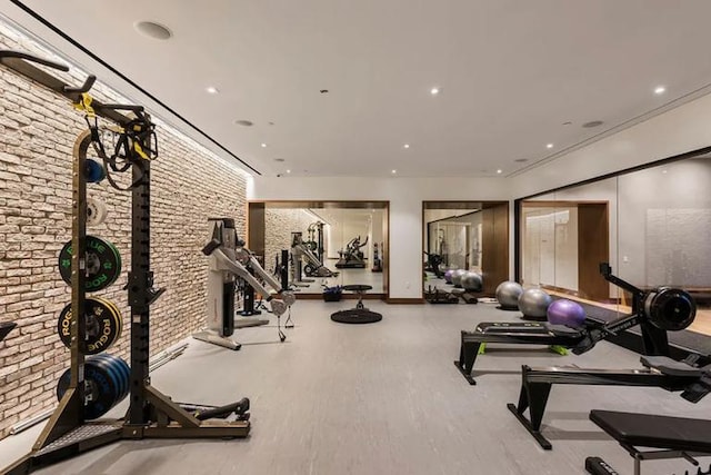 gym with baseboards, brick wall, and recessed lighting