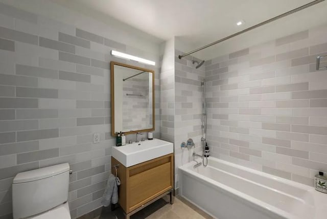 full bathroom featuring toilet, shower / bathing tub combination, vanity, and tile walls