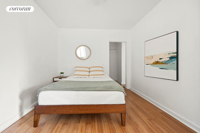 bedroom featuring wood finished floors, visible vents, and baseboards