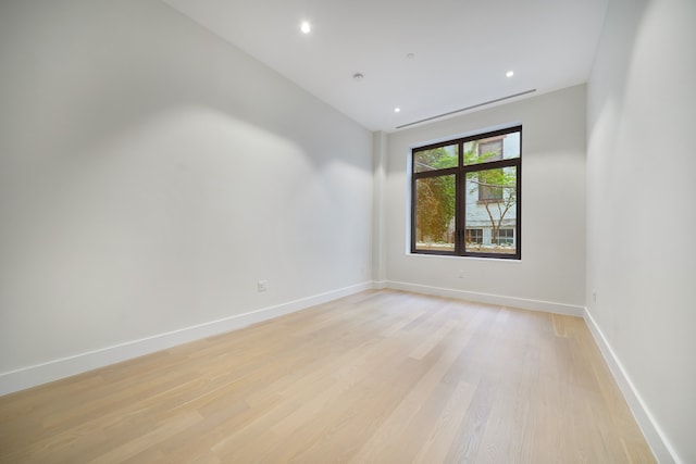 spare room with recessed lighting, baseboards, and light wood-type flooring