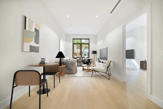 washroom featuring recessed lighting, baseboards, light wood-style flooring, and stacked washing maching and dryer