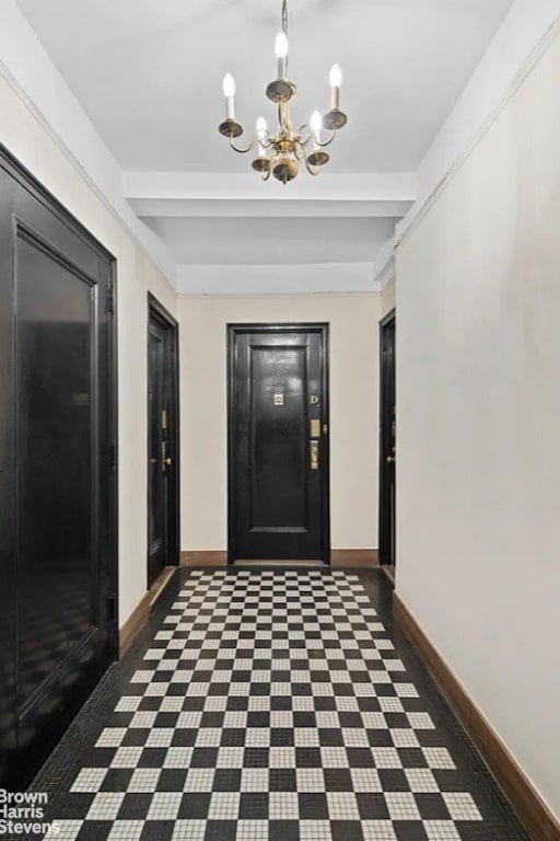 corridor featuring baseboards, a chandelier, and beamed ceiling