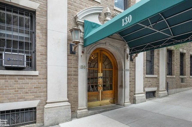 view of exterior entry with french doors and brick siding