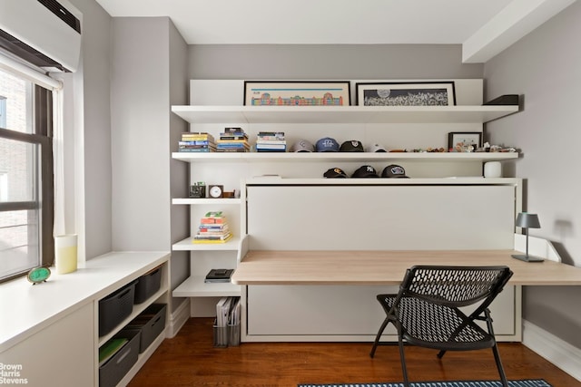 office space with built in desk and dark wood-style flooring