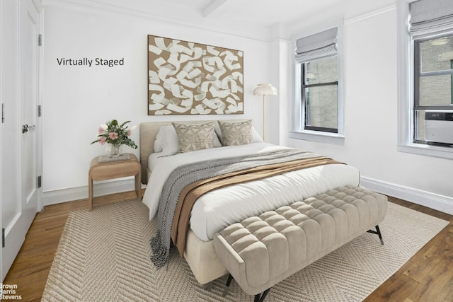 bedroom featuring baseboards and wood finished floors