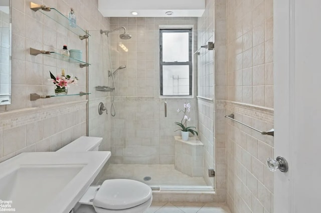 full bathroom with toilet, a stall shower, and tile walls