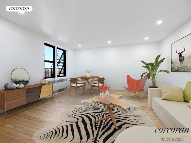 living room featuring visible vents, recessed lighting, light wood-type flooring, and radiator heating unit