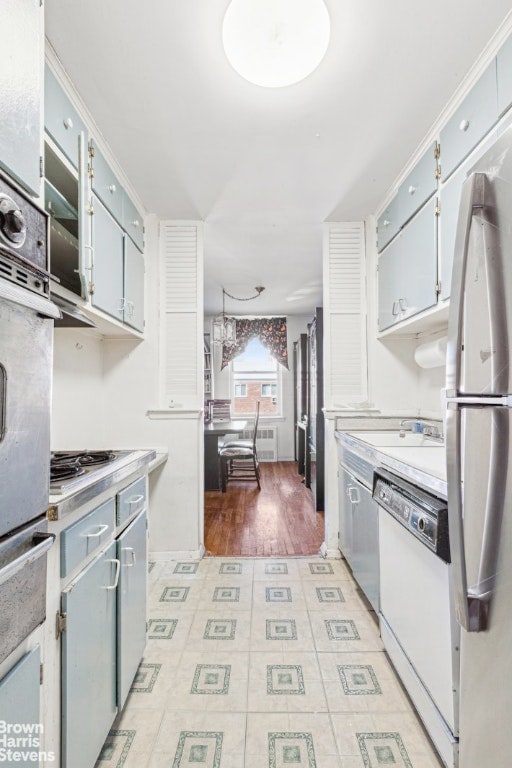 kitchen with light countertops, white dishwasher, gas cooktop, and stainless steel refrigerator