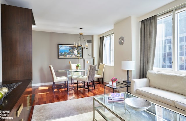 dining space with a notable chandelier, baseboards, and dark wood-style flooring