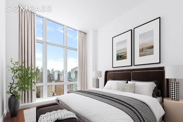 bedroom featuring floor to ceiling windows, a city view, and wood finished floors