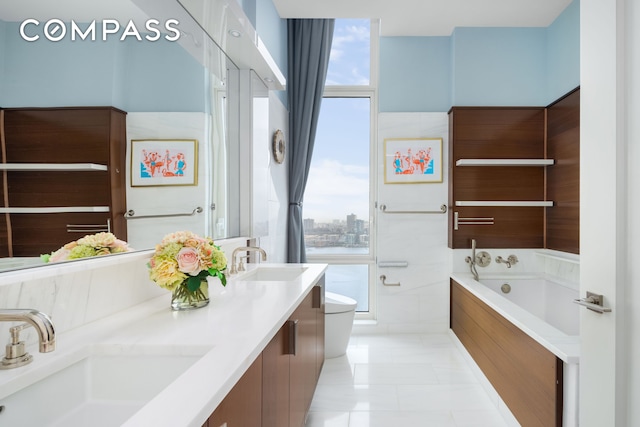 bathroom with toilet, plenty of natural light, a garden tub, and double vanity