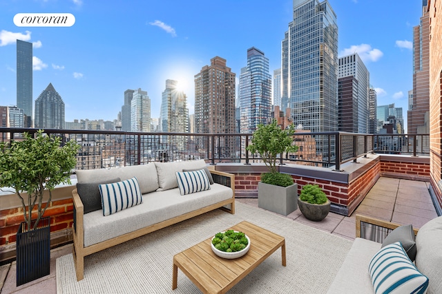 view of patio featuring a balcony, a view of city, and an outdoor hangout area