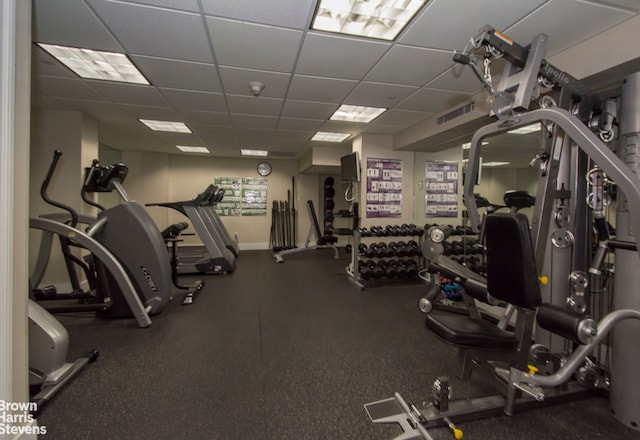 gym with baseboards, visible vents, and a drop ceiling