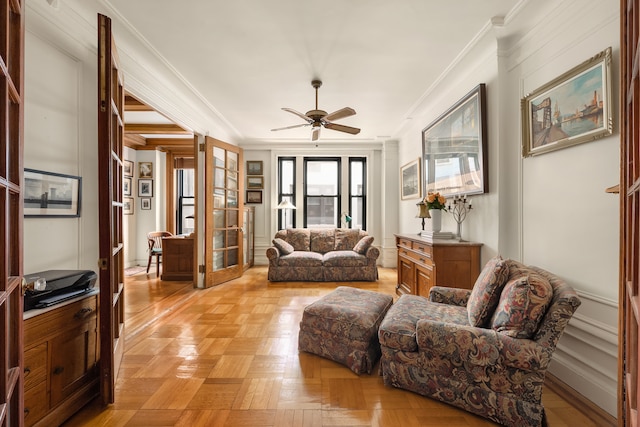 living area featuring a ceiling fan and ornamental molding