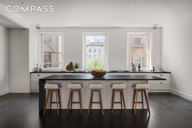 interior space featuring dark countertops, a breakfast bar, and white cabinets