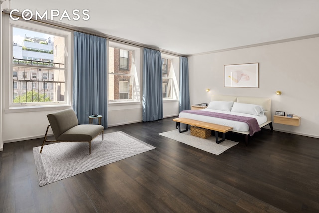 bedroom with ornamental molding, wood finished floors, and baseboards