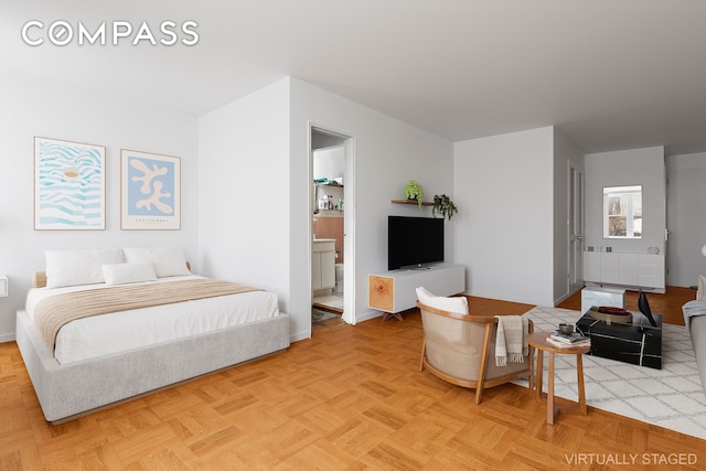 bedroom featuring baseboards and ensuite bath