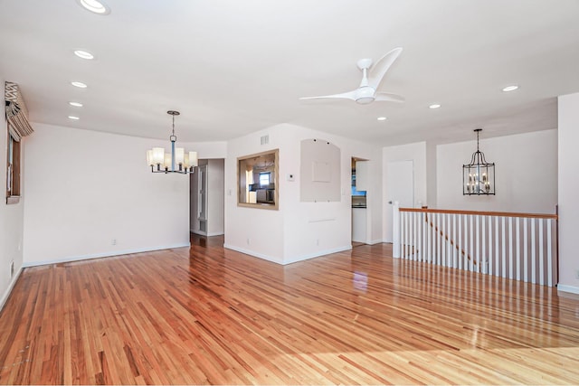 spare room featuring ceiling fan with notable chandelier, recessed lighting, visible vents, and light wood-style floors