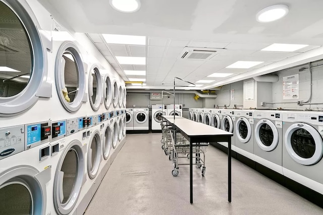 shared laundry area with stacked washer and dryer, washing machine and dryer, and visible vents