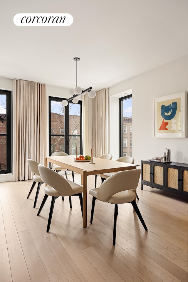 dining room with light wood-style flooring and a notable chandelier