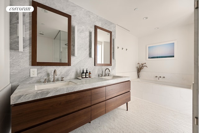 full bathroom featuring double vanity, a sink, a bath, and tile patterned floors