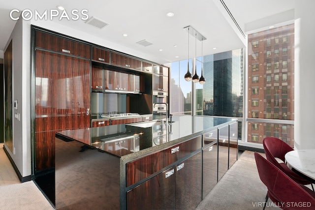 kitchen with visible vents, stainless steel gas cooktop, a city view, a large island, and modern cabinets