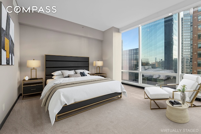 bedroom featuring a wall of windows, baseboards, and carpet floors