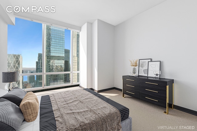 carpeted bedroom with a city view and baseboards