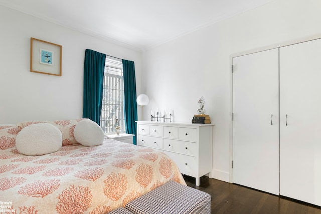 bedroom featuring ornamental molding and dark wood-style flooring