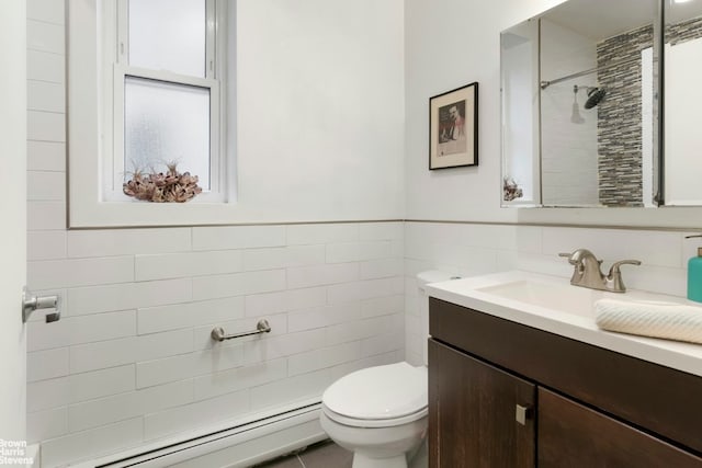 bathroom with tile walls, toilet, baseboard heating, wainscoting, and vanity