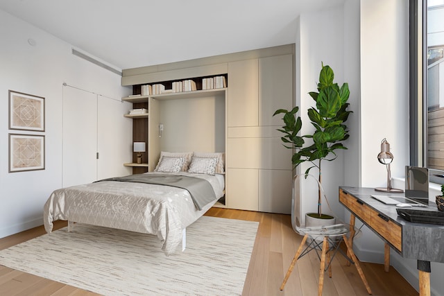 bedroom with light wood-style flooring and a closet