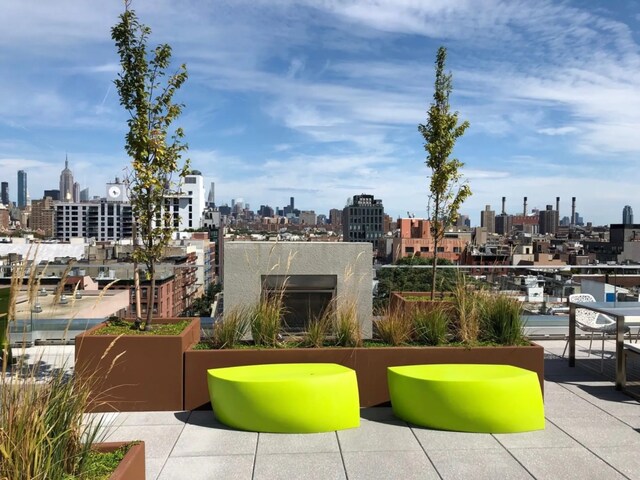 view of patio with an outdoor living space with a fireplace and a city view