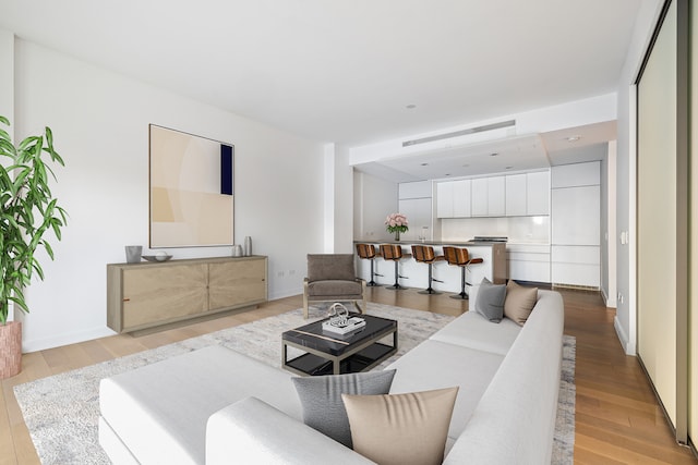 living room with light wood-type flooring and baseboards