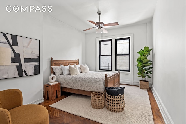 bedroom with wood finished floors, a ceiling fan, and baseboards