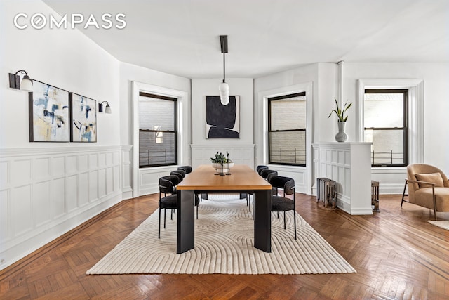 dining area with a decorative wall and wainscoting