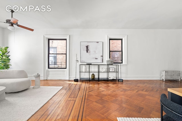 sitting room featuring radiator, ceiling fan, and baseboards