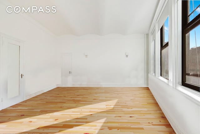 empty room featuring hardwood / wood-style flooring and baseboards