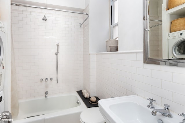 full bath with toilet, shower / bath combination, tile walls, and a sink