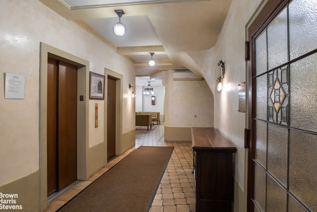 hallway featuring light tile patterned floors, ornamental molding, coffered ceiling, and elevator