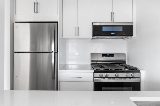 kitchen featuring white cabinetry, stainless steel appliances, and light countertops