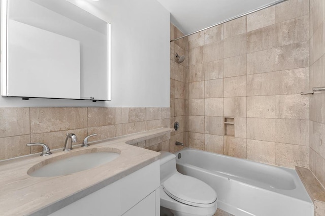 full bathroom with  shower combination, tile walls, vanity, and toilet