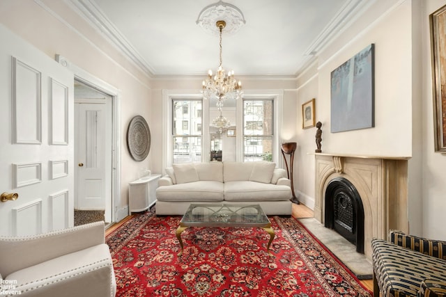 living area with an inviting chandelier, baseboards, crown molding, and a fireplace