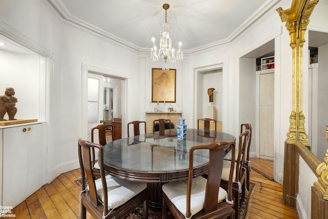 dining area with an inviting chandelier, baseboards, ornamental molding, and light wood-type flooring