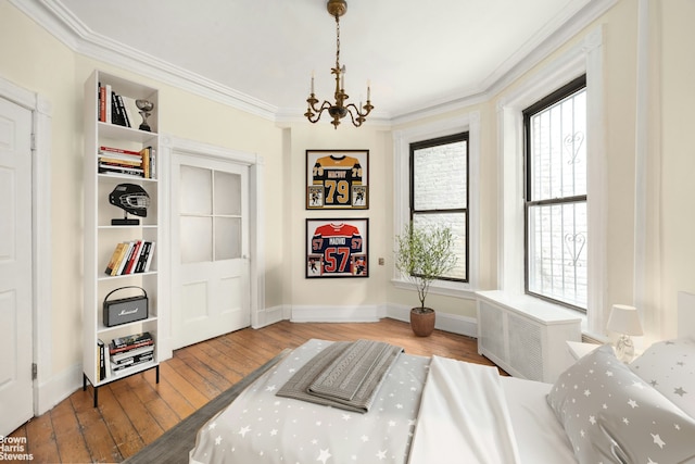 interior space featuring baseboards, a notable chandelier, ornamental molding, and hardwood / wood-style flooring
